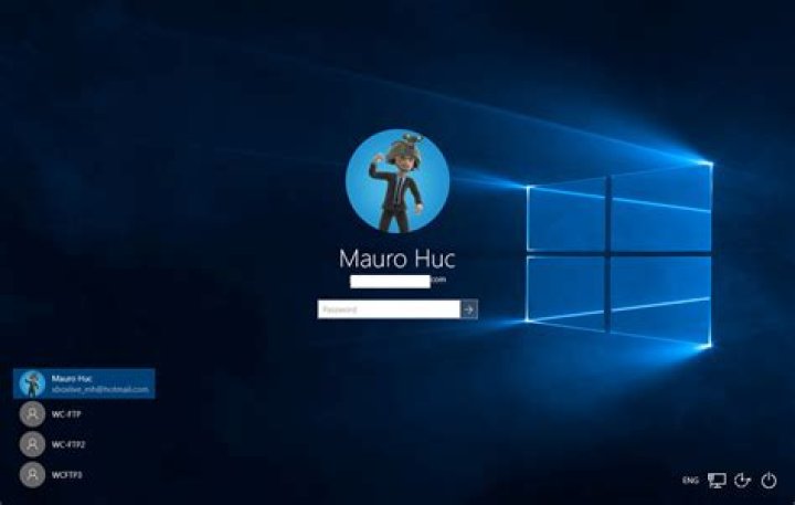 Windows 10 login screen, with accessibility button highlighted in an orange circle.